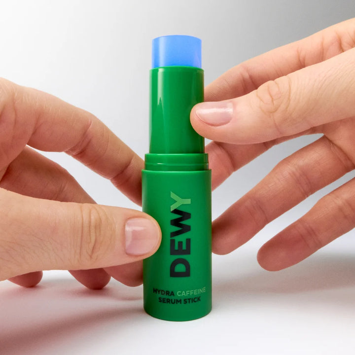 Dewy Hydra Caffeine Serum Stick von Mádara - geöffnet, Hände halten das Serum
