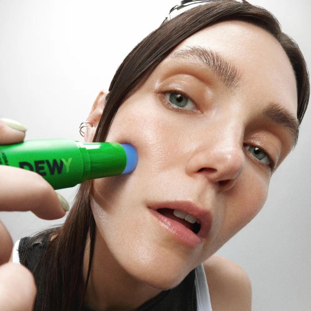 Dewy Hydra Caffeine Serum Stick von Mádara - Model trägt das Serum auf der Wange auf