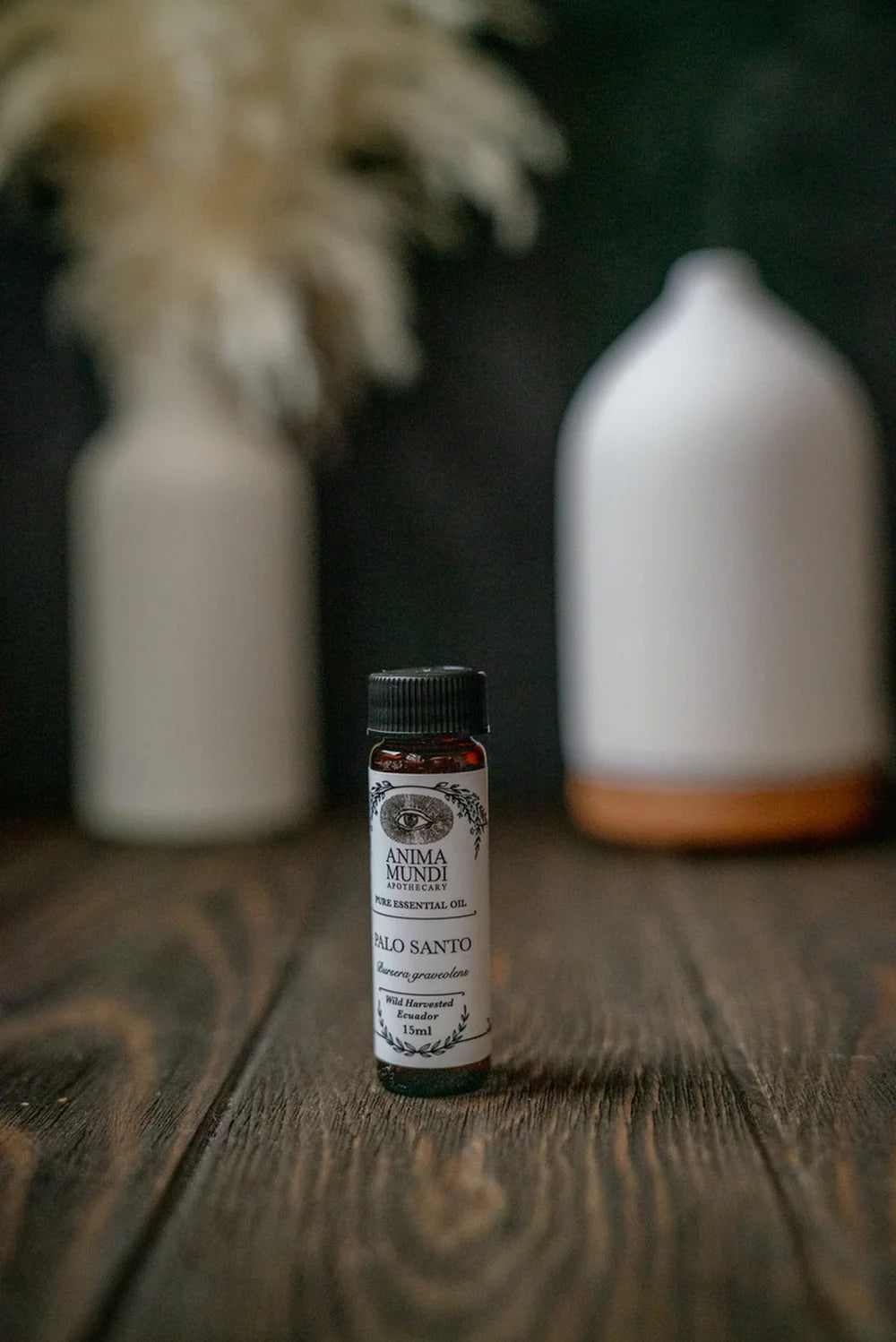 Anima Mundi Palo Santo Essential Oil - Öl-Fläschchen steht auf Holztisch