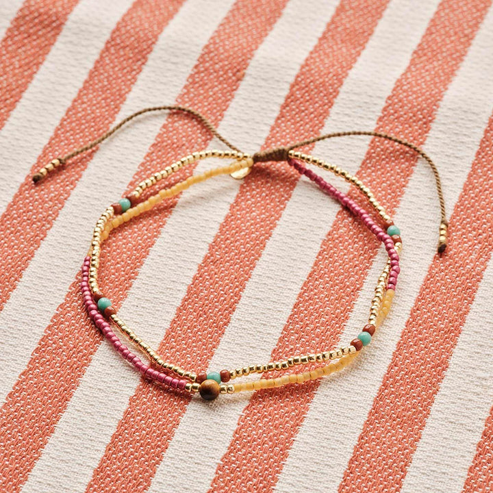 Echo Tiger Eye Anklet - Produktfoto auf gestreiftem Tuch