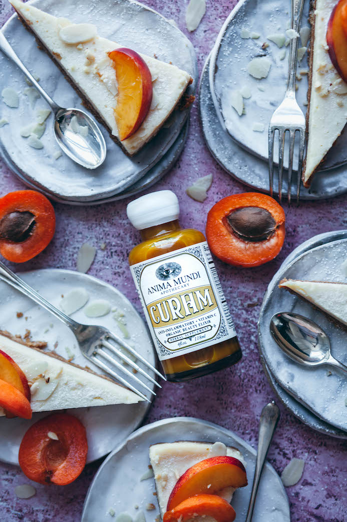 Curam Elixir von Anima Mundi - Produktfoto mit Kuchenstücken, Früchten