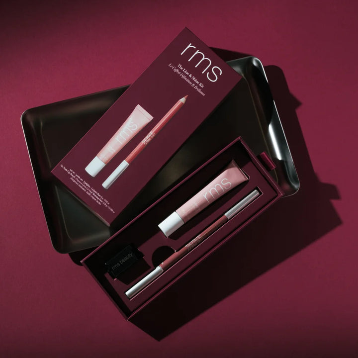 RMS Beauty The Line + Shine Kit mit Lipliner und Lipgloss auf dunkelrotem Hintergrund