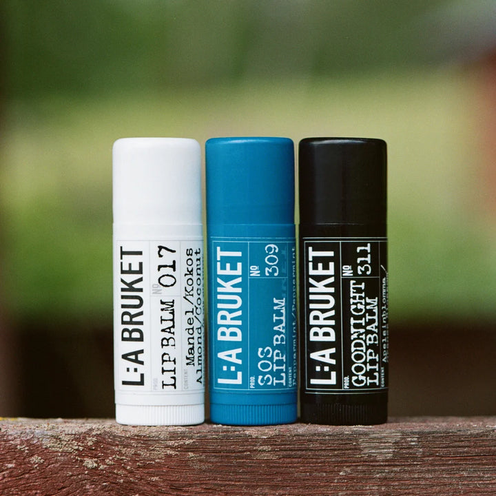Drei Lippenbalsame von L:A Bruket in Weiß, Blau und Schwarz – Goodnight, SOS und 017 Lip Balm