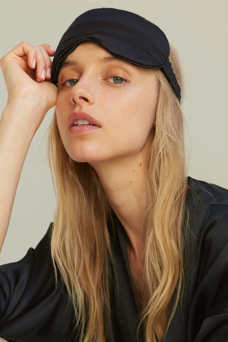 Frau trägt Silk Eye Mask Midnight Black von Dariia Day - hypoallergene Seidenschlafmaske für erholsamen Schlaf