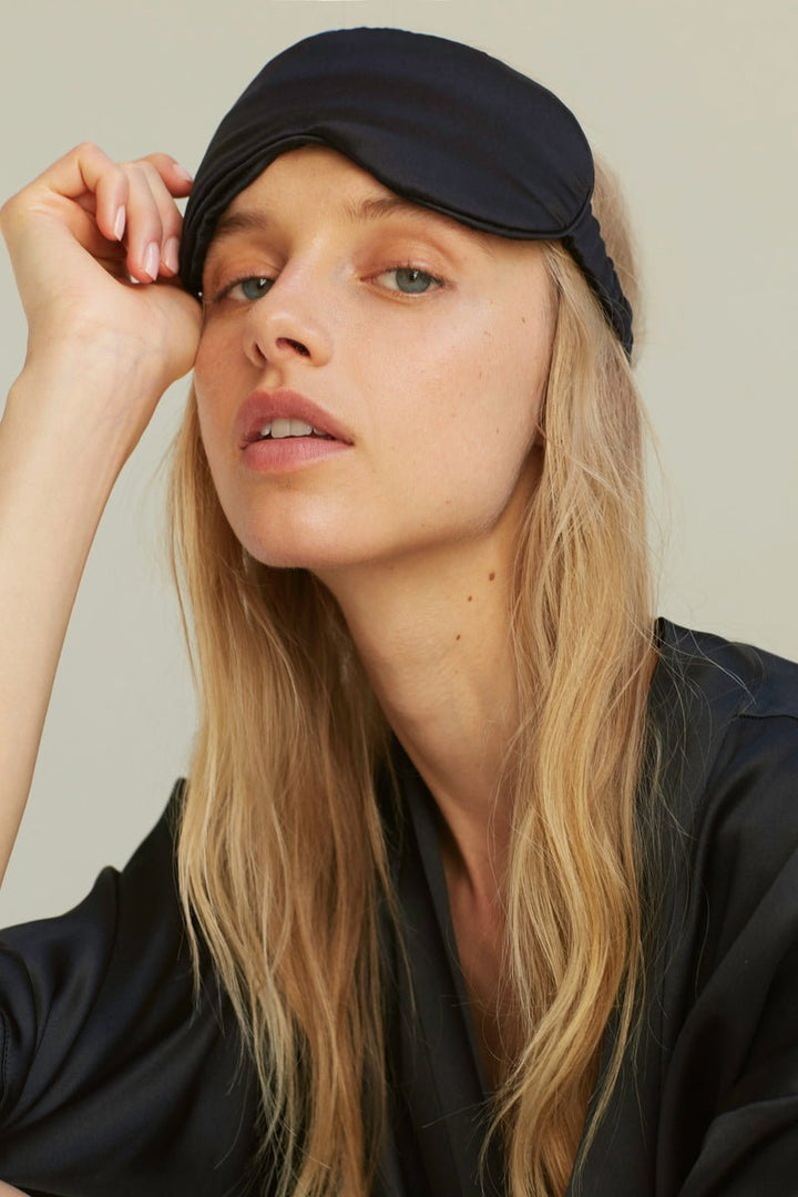 Frau trägt Silk Eye Mask Midnight Black von Dariia Day - hypoallergene Seidenschlafmaske für erholsamen Schlaf