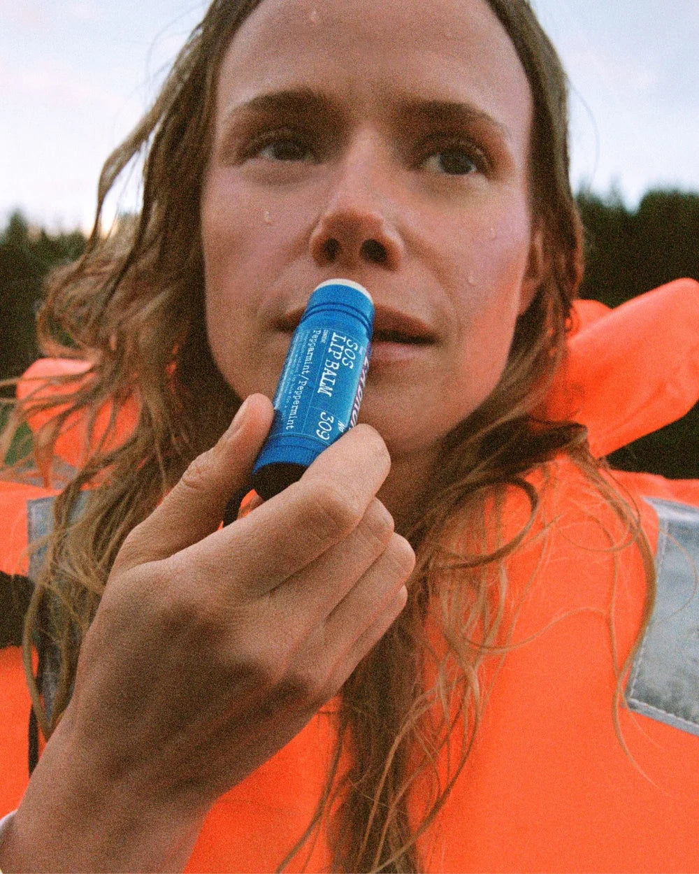 Frau trägt den L:A Bruket SOS Lip Balm mit Pfefferminze auf ihre Lippen auf