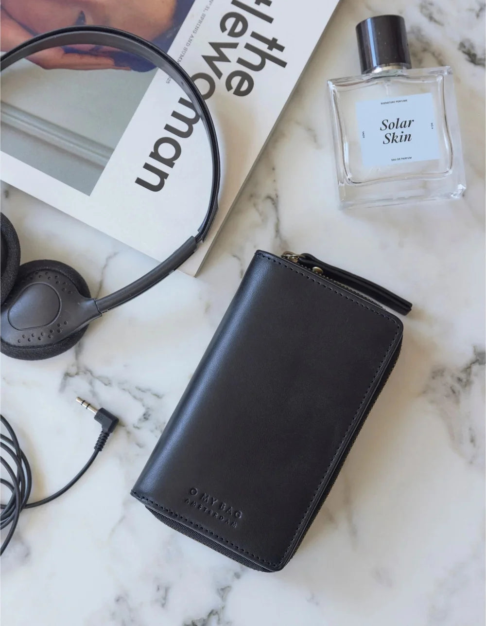 O My Bag Jett Wallet Black – hochwertige Ledergeldbörse mit persönlichen Accessoires auf hellem Untergrund