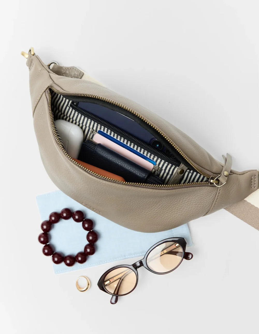 O My Bag Niko – geöffnete Ledertasche mit Smartphone und persönlichen Gegenständen