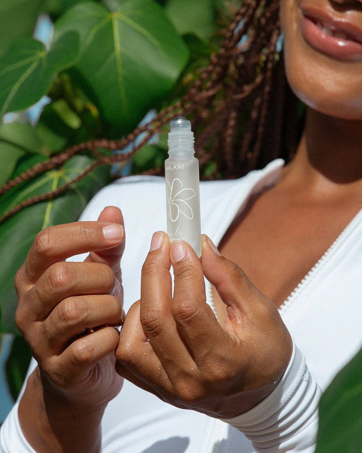 Leahlani Pua Lei Perfume Oil – geöffneter Rollerball-Flakon in den Händen, Detailaufnahme