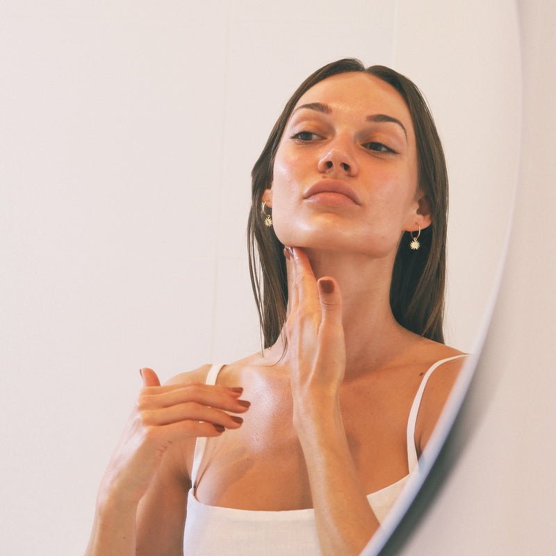 Model trägt Wildcrafted Organics Bakuchiol Serum auf Hals und Dekolleté auf
