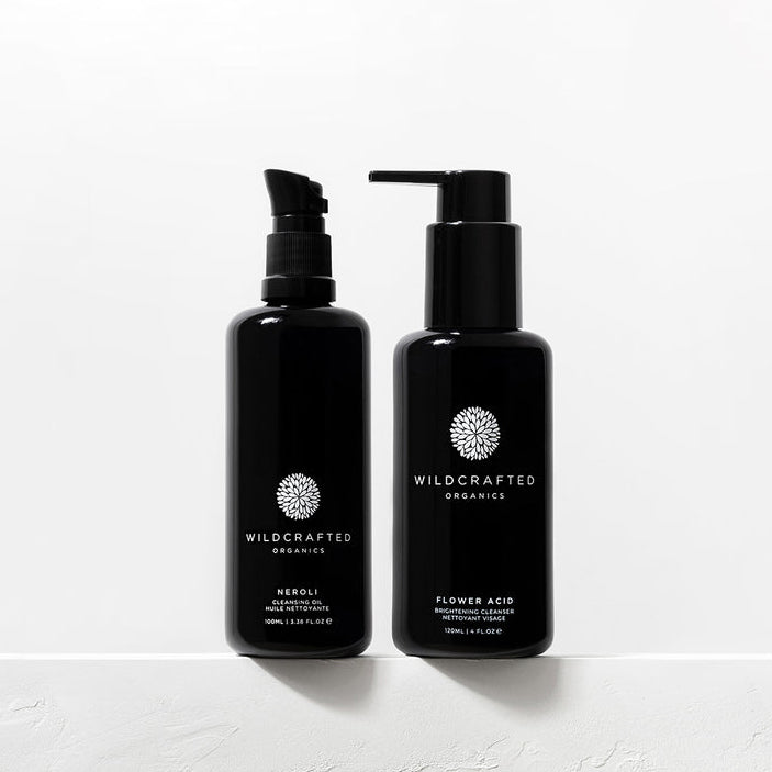 Wildcrafted Organics Neroli Hydrating Milk Cleanser und Flower Acid Brightening Cleanser Flaschen nebeneinander auf weißem Hintergrund