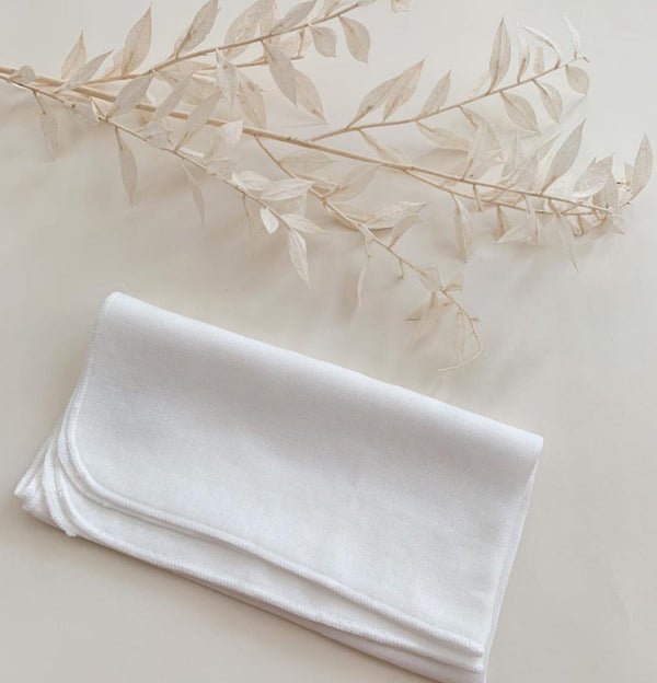 Wildcrafted Organics Luxury Organic Muslin Cleansing Cloths - gefaltetes weißes Musselin-Tuch mit dekorativem Zweig