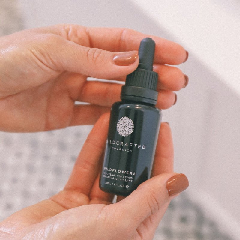 Hände halten Wildcrafted Organics Wildflowers Rejuvenating Serum 30ml Flasche mit Pipette