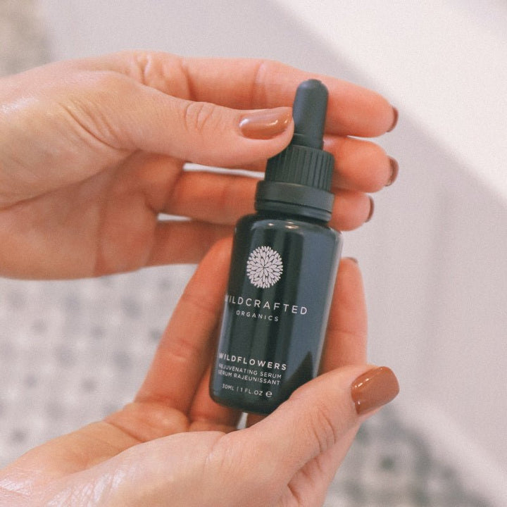 Hände halten Wildcrafted Organics Wildflowers Rejuvenating Serum 30ml Flasche mit Pipette